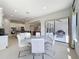 Open-concept dining area with modern table and chairs, and view to kitchen and outdoor patio at 2630 Milford Berry Ln, Tampa, FL 33618