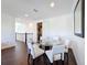 Cozy dining area with a glass table and white chairs, complemented by dark wood floors and bright lighting at 2630 Milford Berry Ln, Tampa, FL 33618
