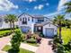 Beautiful two-story home with a three car garage, a brick driveway, and lush landscaping at 2630 Milford Berry Ln, Tampa, FL 33618
