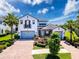 Beautiful two-story home with a three car garage, a brick driveway, and lush landscaping at 2630 Milford Berry Ln, Tampa, FL 33618