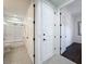 Hallway with white doors that lead to a tiled bathroom and bedroom, connecting various areas of the home at 2630 Milford Berry Ln, Tampa, FL 33618