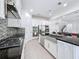 Bright, open kitchen with stainless steel appliances, granite counters, and view to staircase at 2630 Milford Berry Ln, Tampa, FL 33618