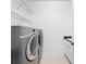 Well-equipped laundry room with modern washer, dryer, wire shelving, and white cabinetry, offering efficient space for laundry tasks at 2630 Milford Berry Ln, Tampa, FL 33618