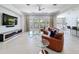 Bright living room with tile floors, a leather couch, and an open view to the kitchen and dining areas at 2630 Milford Berry Ln, Tampa, FL 33618