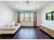 Bright living room showcasing dark wood floors, a modern media console, and comfortable seating at 2630 Milford Berry Ln, Tampa, FL 33618