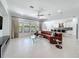 Open-concept living room features a large leather couch, tile flooring, and a view into the kitchen area at 2630 Milford Berry Ln, Tampa, FL 33618