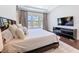 Main bedroom includes wood floors, neutral walls, a bench, and large windows for natural light at 2630 Milford Berry Ln, Tampa, FL 33618