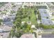 Aerial view of the community park showcasing a playground, picnic pavilion, and clubhouse nestled among tree-lined streets at 3465 Bumelia Ln, New Port Richey, FL 34655