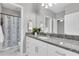 Bathroom vanity with granite countertops and patterned shower at 3465 Bumelia Ln, New Port Richey, FL 34655