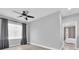 Neutral bedroom showcasing natural light, a ceiling fan, and gray curtains at 3465 Bumelia Ln, New Port Richey, FL 34655
