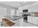 Modern kitchen with white cabinets, stainless steel appliances, and a granite island with bar seating at 3465 Bumelia Ln, New Port Richey, FL 34655