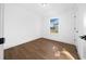 Bright bedroom features wood-look flooring, a window with view, and fresh white walls at 3592 Arrowhead Ave, Spring Hill, FL 34606
