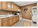 Functional kitchen featuring wood cabinets, white countertops and appliances, with a back door at 4725 3Rd S Ave, St Petersburg, FL 33711