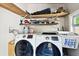 Functional laundry room featuring modern white washer and dryer with convenient built-in storage shelving at 4725 3Rd S Ave, St Petersburg, FL 33711