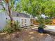A partial view of a backyard shed and a covered carport surrounded by green plants and trees at 4816 N Highland Ave, Tampa, FL 33603
