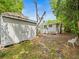 Backyard with mature trees and a storage shed adjacent to the house, providing ample outdoor space at 4816 N Highland Ave, Tampa, FL 33603