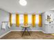 Dining area with yellow curtains, wood-look flooring, and natural light at 4816 N Highland Ave, Tampa, FL 33603