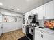 Kitchen with stainless steel oven and microwave, white cabinets, subway tile backsplash, and wood-look flooring at 4816 N Highland Ave, Tampa, FL 33603