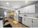 Bright kitchen with stainless steel appliances, white cabinets, subway tile backsplash, and wood-look flooring at 4816 N Highland Ave, Tampa, FL 33603