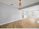 Spacious living area showcasing wood-look flooring, a decorative light fixture, and an open layout at 4816 N Highland Ave, Tampa, FL 33603