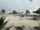 Picturesque beach featuring white sand, tropical trees, cabanas, and relaxing blue chairs for the perfect sunny day at 4939 Floramar Ter # 810, New Port Richey, FL 34652