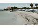 Sandy beach featuring lounge chairs with shaded canopies overlooking tranquil water at 4939 Floramar Ter # 810, New Port Richey, FL 34652