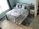 Bedroom featuring coastal themed bedding and cool toned accents at 4939 Floramar Ter # 810, New Port Richey, FL 34652