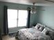 Bright bedroom featuring a ceiling fan, coastal themed bedding, and window at 4939 Floramar Ter # 810, New Port Richey, FL 34652