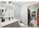 Well-lit bathroom with modern fixtures, gray vanity, and a view of a walk-in closet at 5500 Leahy Ln, New Port Richey, FL 34652