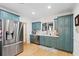 Charming kitchen featuring light blue cabinets, stainless steel appliances, and hardwood floors at 5500 Leahy Ln, New Port Richey, FL 34652