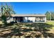 Rear exterior shot of home featuring a screened in patio and carport at 6012 Landover Blvd, Spring Hill, FL 34609