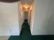 Hallway with green carpet leading to multiple rooms at 6012 Landover Blvd, Spring Hill, FL 34609
