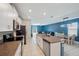 Open-concept kitchen with island, stainless appliances, and adjacent dining area with natural light at 6068 Apple Snail Ave, New Port Richey, FL 34653