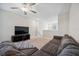 Comfortable living room features a plush sectional sofa, ceiling fan, and bright window at 6068 Apple Snail Ave, New Port Richey, FL 34653