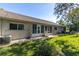 Back exterior with lush green lawn, a patio, and a view of the home's architecture at 6420 Cabbage Ln, New Port Richey, FL 34653