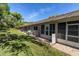 Back exterior view of a home with a well-kept lawn and partially screened patio at 6420 Cabbage Ln, New Port Richey, FL 34653
