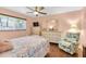 Bright bedroom featuring a ceiling fan, wooden floors, and comfortable furniture at 6420 Cabbage Ln, New Port Richey, FL 34653