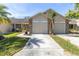 Charming home with a two-car garage, manicured lawn, and mature landscaping at 6420 Cabbage Ln, New Port Richey, FL 34653