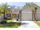 Charming single-story home featuring a well-maintained lawn, palm tree, and attached two-car garage at 6420 Cabbage Ln, New Port Richey, FL 34653