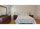 Well-lit bedroom with comfortable bedding, dresser, and hardwood floors at 6530 Pine Meadows Dr, Spring Hill, FL 34606
