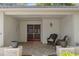 Close-up of front porch featuring brick flooring, comfortable wicker seating, and decorative plants at 6530 Pine Meadows Dr, Spring Hill, FL 34606