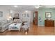 Bright living room with wood floors, comfortable seating, and access to the front entrance at 6530 Pine Meadows Dr, Spring Hill, FL 34606
