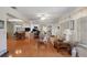 Bright, open living room featuring hardwood floors, large windows, and views into the dining and office areas at 6530 Pine Meadows Dr, Spring Hill, FL 34606