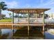 Waterfront dock featuring seating area with covered roof and white picket fence at 6536 Beach Blvd, Hudson, FL 34667