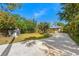 Wide shot of the backyard showing a storage shed and spacious gravel driveway at 7240 Creek Dr, New Port Richey, FL 34655