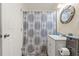 Bathroom featuring a vanity with storage, decorative mirror, and a shower with a patterned curtain at 7240 Creek Dr, New Port Richey, FL 34655