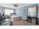 Cozy bedroom with blue walls, a comfortable bed, and desk area illuminated by natural light at 7240 Creek Dr, New Port Richey, FL 34655