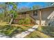 Charming home exterior with wooden deck, stone pathway, and vibrant landscaping at 7240 Creek Dr, New Port Richey, FL 34655