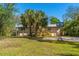 Spacious home exterior with metal roof, lush yard, and a basketball hoop for outdoor fun at 7240 Creek Dr, New Port Richey, FL 34655