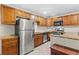 Kitchen featuring stainless steel appliances, wooden cabinets and granite countertops at 7240 Creek Dr, New Port Richey, FL 34655
